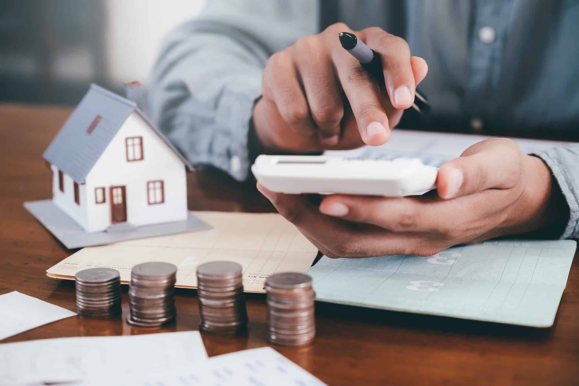 Businessman is Savings money and calculating.Save money for home cost